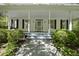 Spacious front porch with classic columns and a swing, surrounded by lush landscaping at 216 Dairyland Rd, Chapel Hill, NC 27516
