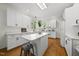 Updated kitchen boasts white cabinetry, quartz countertops, stainless steel appliances and a functional center island at 216 Dairyland Rd, Chapel Hill, NC 27516