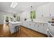Bright kitchen with island, white cabinets, quartz counters, stainless appliances, and open view to the adjacent breakfast area at 216 Dairyland Rd, Chapel Hill, NC 27516