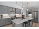 Contemporary kitchen featuring gray cabinets, stainless steel appliances, a center island with seating, and lots of lighting at 2225 Millbank Village Ct # 101, Raleigh, NC 27610