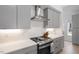 Modern kitchen with gray cabinets, white countertops, a stainless steel range hood, and a gas cooktop at 2225 Millbank Village Ct # 101, Raleigh, NC 27610
