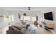 Bright living room features a comfortable gray sofa, modern furniture, a ceiling fan, and several windows at 2225 Millbank Village Ct # 101, Raleigh, NC 27610