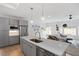 Bright open-concept kitchen and living area with gray cabinets, stainless steel appliances, and lots of windows at 2225 Millbank Village Ct # 101, Raleigh, NC 27610