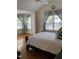 Bedroom with a queen-sized bed and seating area, wooden floors, and a large window at 2305 Summit Dr, Hillsborough, NC 27278