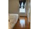 Simple bedroom with a window, hardwood floors, and doorway at 2305 Summit Dr, Hillsborough, NC 27278