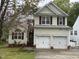 Inviting two-story home with garage, brick accents, manicured lawn, and a cozy sitting area in the yard at 2305 Summit Dr, Hillsborough, NC 27278
