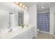 Bright bathroom features a double vanity, shower and tub with modern patterned shower curtain at 2411 Vancastle Way # 202, Raleigh, NC 27617