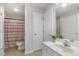 Well-lit bathroom featuring vanity, tiled floors and shower with multicolored shower curtain at 2411 Vancastle Way # 202, Raleigh, NC 27617