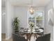 Cozy dining area featuring a glass-top table, modern chairs, stylish light fixture, and bright window at 2411 Vancastle Way # 202, Raleigh, NC 27617