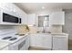 Bright kitchen with white appliances, cabinetry, a stainless steel sink, and a window offering a functional and modern space at 2411 Vancastle Way # 202, Raleigh, NC 27617