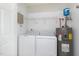 Laundry room with white washer and dryer, as well as a hot water heater at 2411 Vancastle Way # 202, Raleigh, NC 27617