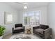 Charming sitting room with two plush chairs, a decorative mirror, ample natural light, and a cozy atmosphere at 2411 Vancastle Way # 202, Raleigh, NC 27617