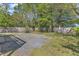 Fenced backyard with a combination of gravel and grass, and mature shade trees at 2522 N Roxboro St, Durham, NC 27704