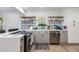 Bright kitchen with stainless steel dishwasher, gray cabinets, open wood shelving, and unique star pattern backsplash at 2522 N Roxboro St, Durham, NC 27704