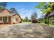 Spacious back patio with brick accents and access to a sprawling green lawn with mature trees at 254 Pine Forest Dr, Siler City, NC 27344