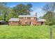Expansive lawn behind this traditional brick home featuring mature trees and landscaping at 254 Pine Forest Dr, Siler City, NC 27344