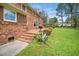 Brick patio extends from the home, featuring a grill and lush greenery surrounding the yard at 254 Pine Forest Dr, Siler City, NC 27344