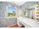 Well-lit vanity area with a makeup station featuring decorative floral wallpaper at 254 Pine Forest Dr, Siler City, NC 27344