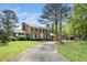 Traditional two-story brick home with a long driveway and mature trees at 254 Pine Forest Dr, Siler City, NC 27344