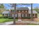 Traditional brick home with black shutters, manicured landscaping, and mature trees lining the walkway at 254 Pine Forest Dr, Siler City, NC 27344