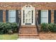 Close-up of front door framed by sidelights, classic brick stairs, and manicured landscaping at 254 Pine Forest Dr, Siler City, NC 27344