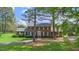 Charming brick home with dark shutters, set back from the street amongst mature trees at 254 Pine Forest Dr, Siler City, NC 27344