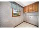 Small, traditional laundry room with patterned wallpaper and tile flooring at 254 Pine Forest Dr, Siler City, NC 27344