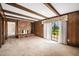 Cozy living room with brick fireplace, wood paneling, and exposed beam ceiling at 254 Pine Forest Dr, Siler City, NC 27344