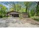 Rustic outbuilding featuring covered parking and a storage shed, set amidst lush greenery at 254 Pine Forest Dr, Siler City, NC 27344