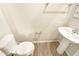 Well-lit half bathroom with modern toilet and sink with neutral walls and wood-style flooring at 32 Bellini Dr, Angier, NC 27501