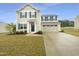 Charming two-story home boasts a classic design, complemented by a well-manicured lawn and an inviting driveway at 32 Bellini Dr, Angier, NC 27501