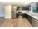 Updated kitchen with stainless steel appliances, dark cabinets, and wood-style flooring at 32 Bellini Dr, Angier, NC 27501