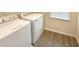 Bright laundry room with a modern washer and dryer and wood-style flooring at 32 Bellini Dr, Angier, NC 27501