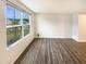 Bright and airy living room showcasing wood-look floors and a large window with a view of the neighborhood at 32 Bellini Dr, Angier, NC 27501
