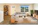 Bright living room features a comfortable sofa, stylish decor, and ample natural light from the large window at 32 Bellini Dr, Angier, NC 27501