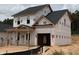 New two-story home featuring an attached garage and covered entryway with decorative brick columns at 322 Bluejay St, Clayton, NC 27520
