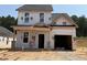 Under-construction two-story home with garage and covered entry, pre-drywall, nestled in a serene wooded area at 322 Bluejay St, Clayton, NC 27520