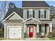 Charming two-story home with a red door, a white garage door and a manicured lawn at 322 Bluejay St, Clayton, NC 27520