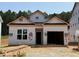 Exterior view of a home under construction with a garage and a yard with building materials at 330 Bluejay St, Clayton, NC 27520