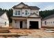 Two-story home with an attached garage under construction featuring newly installed windows and a dark roof at 338 Bluejay St, Clayton, NC 27520