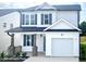 Charming two-story home featuring a garage, black shutters and a covered porch with brick supports at 338 Bluejay St, Clayton, NC 27520