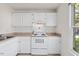 Well-lit kitchen featuring white cabinets, countertops, and appliances; window offers natural light at 359 Kilarney Dr, Durham, NC 27703
