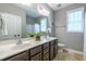 Well-lit bathroom features a double vanity, neutral tones, and a window bringing in natural light at 4290 Sustain Cir, Franklinton, NC 27525