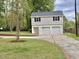 Two-car garage with an upper level and extended driveway surrounded by lush landscaping at 508 & 510 Gordon St, Roxboro, NC 27573