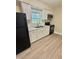 The kitchen features white cabinets, black appliances, wood-look floors and a window at 508 & 510 Gordon St, Roxboro, NC 27573