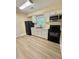 The kitchen features white cabinets, black appliances, wood-look floors and a window at 508 & 510 Gordon St, Roxboro, NC 27573