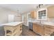 Bright kitchen with stainless steel appliances and wood cabinets, island and white countertops at 508 Baygall Rd, Holly Springs, NC 27540