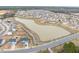Aerial view of a housing community with a pond with walking path and maintained landscaping at 512 Oak Holly Ln, Zebulon, NC 27597