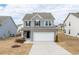 Charming two-story home featuring a two-car garage, stone accents, and a well-manicured lawn at 512 Oak Holly Ln, Zebulon, NC 27597