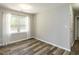 Cozy bedroom features wood-look flooring, neutral walls, and a bright window with sheer curtains at 519 Touchstone Dr, Durham, NC 27713